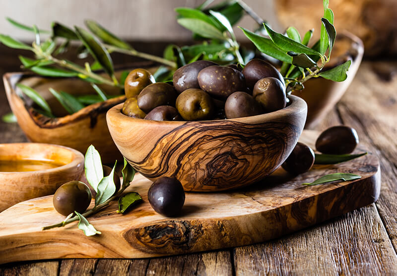 olives-and-olive-oil-in-wooden-plates-and-cutting-board