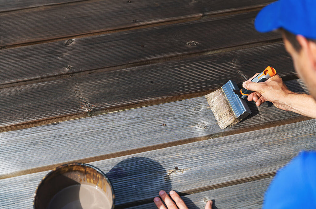 man-oiling -wooden-terrace