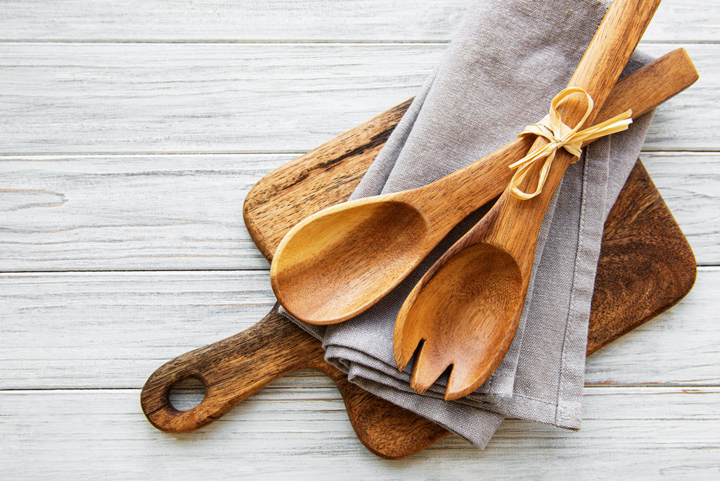 wooden-cutting-board-and-salad-spoons-and-a-kitchen-towel