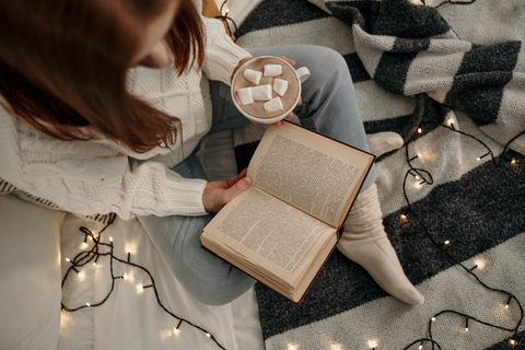 A hot chocolate in bed with string lights