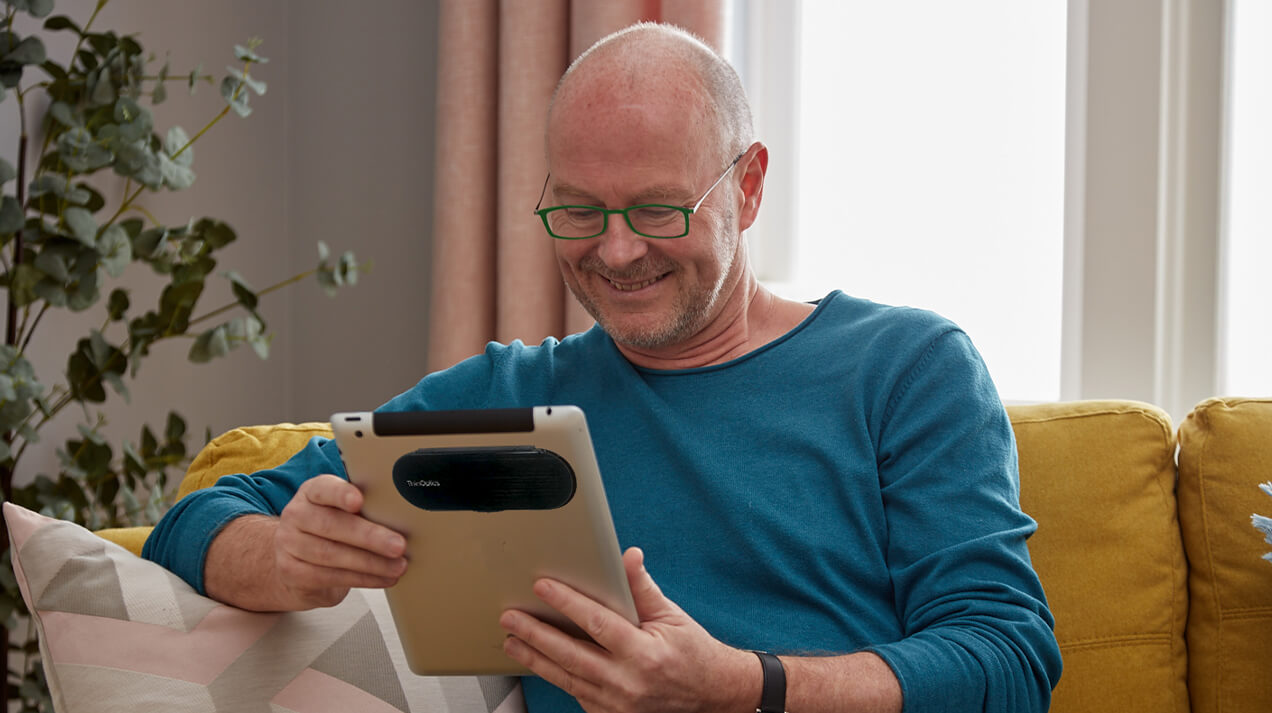 Man wearing Brooklyn Reading Glasses while looking at a table with a Milano Case adhered to the back