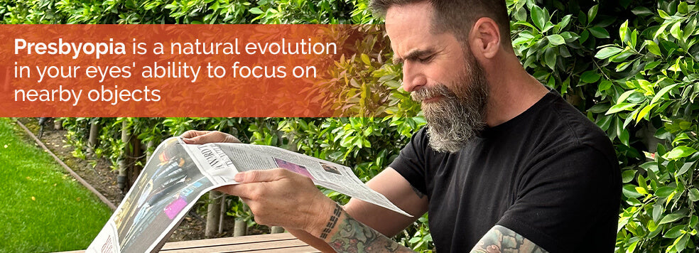 Man squinting at a newspaper with no reading glasses on