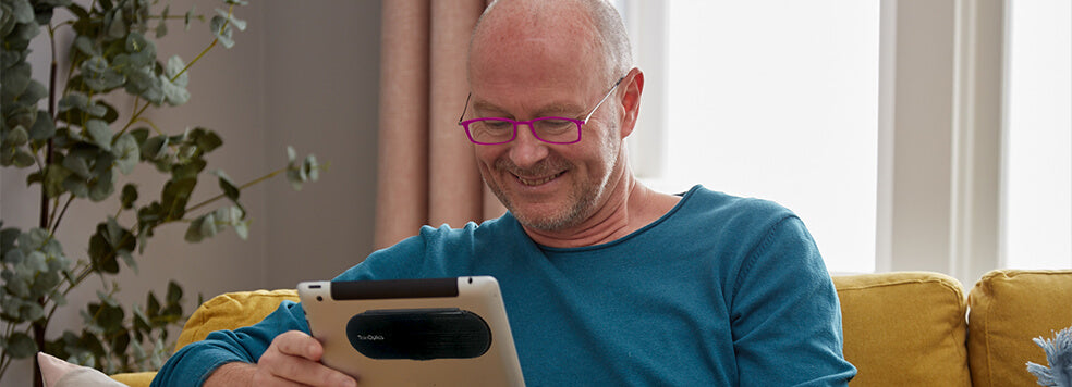 Man wearing Pink Brooklyn Reading Glasses while looking at his tablet