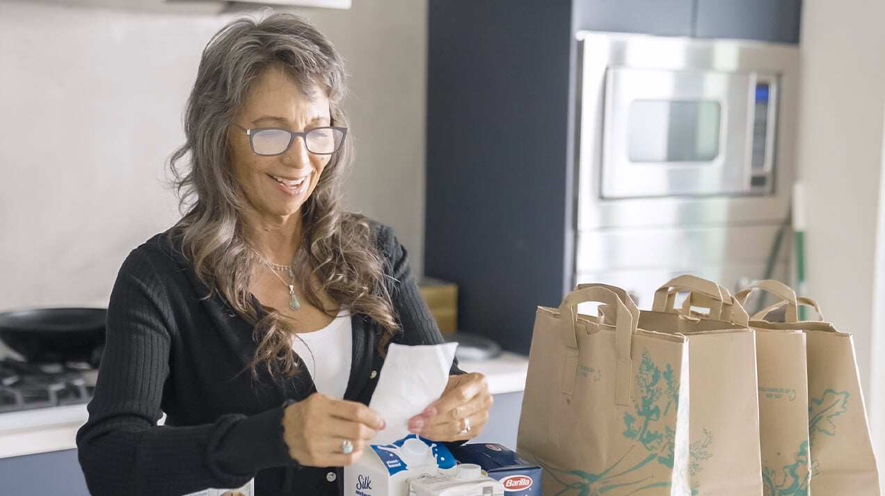 Woman reading her grocery receipt while wearing Connect Reading Glasses
