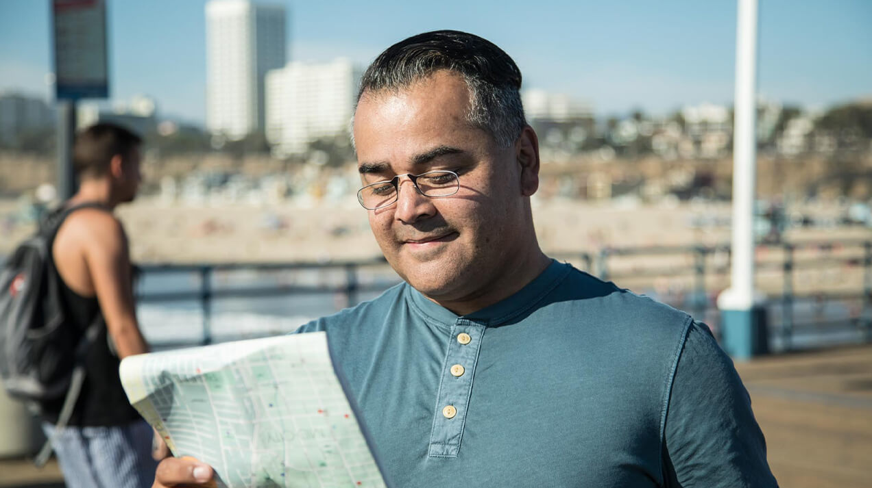 Man wearing Readers while reading a map outdoors