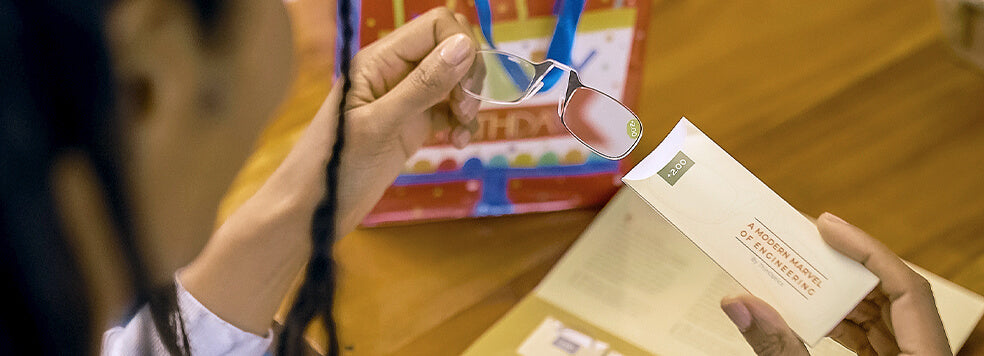 Woman removing a pair of Readers from the sleeve in the Clarity Kit