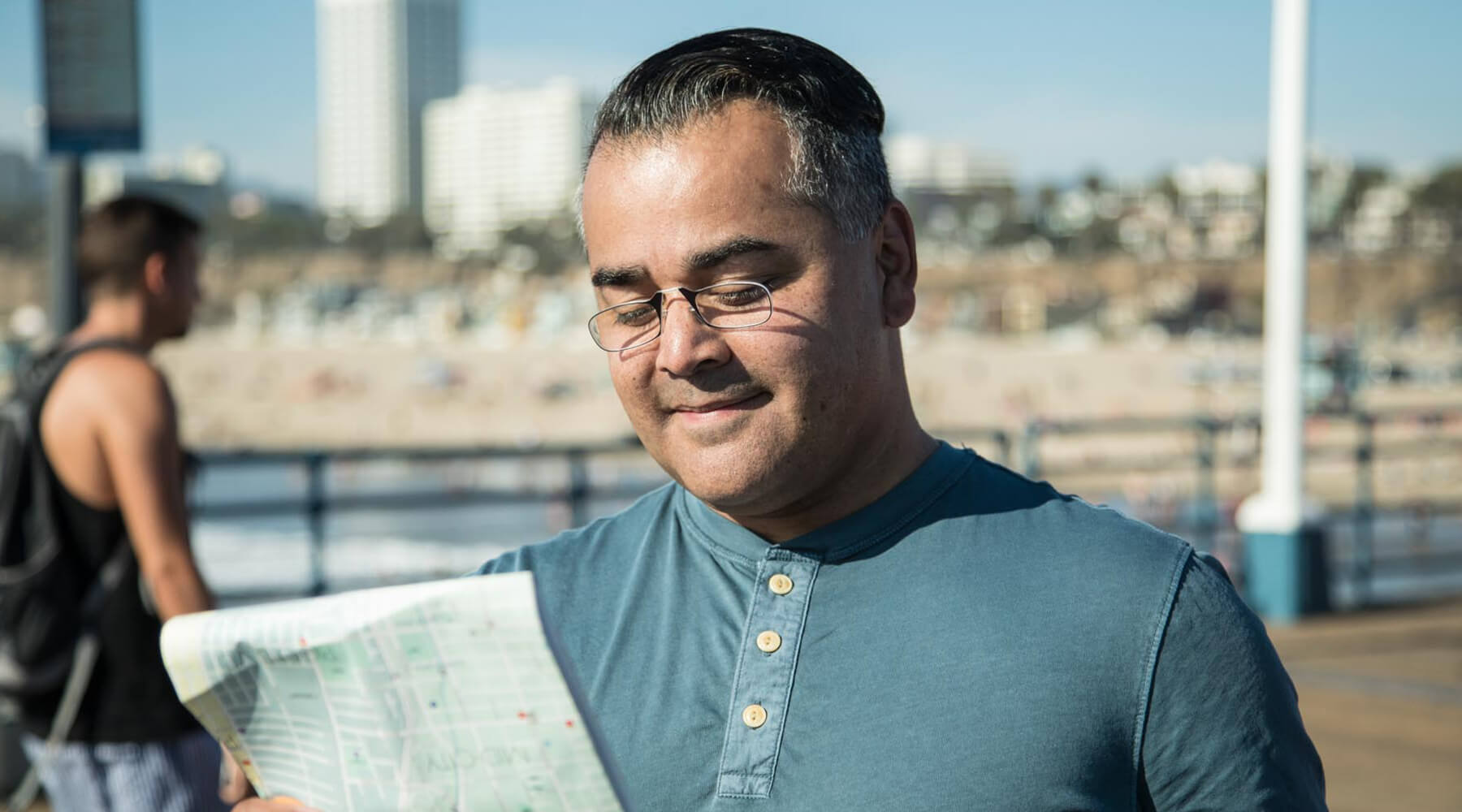 Man wearing Readers while looking at a map at the Santa Monica
