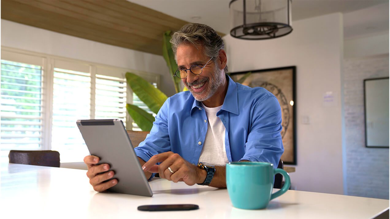 Man wearing Manhattan Blue Light Blocking Reading Glasses while looking at a tablet. 