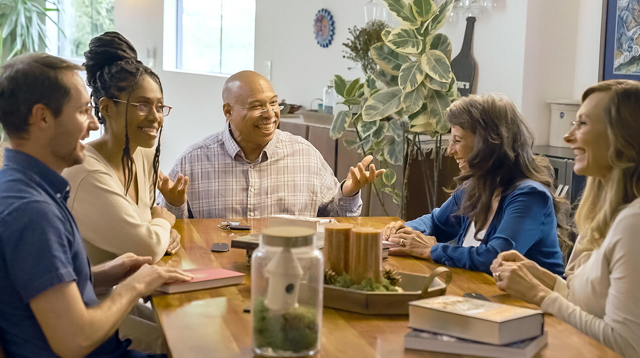 Group of friends sitting around a table, all wearing ThinOptics Vision Solutions