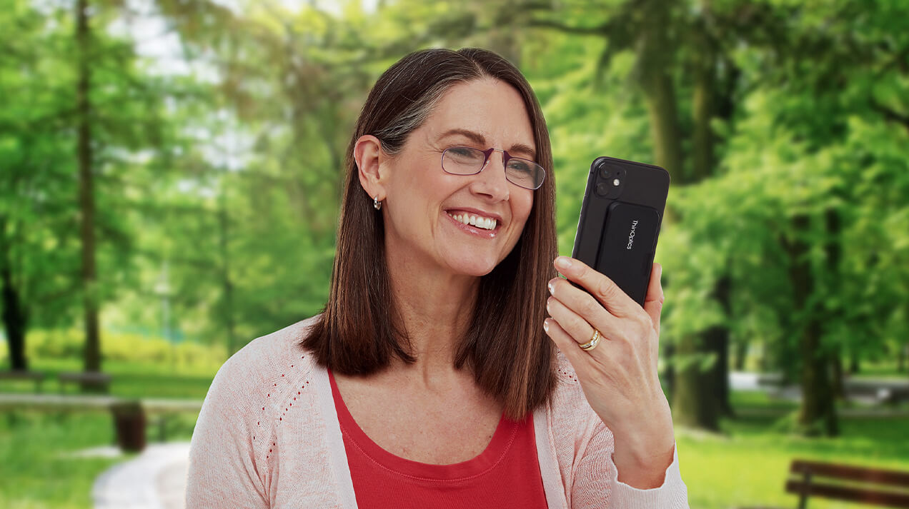 Woman wearing Readers with a Universal Pod on the back of the phone she's looking at
