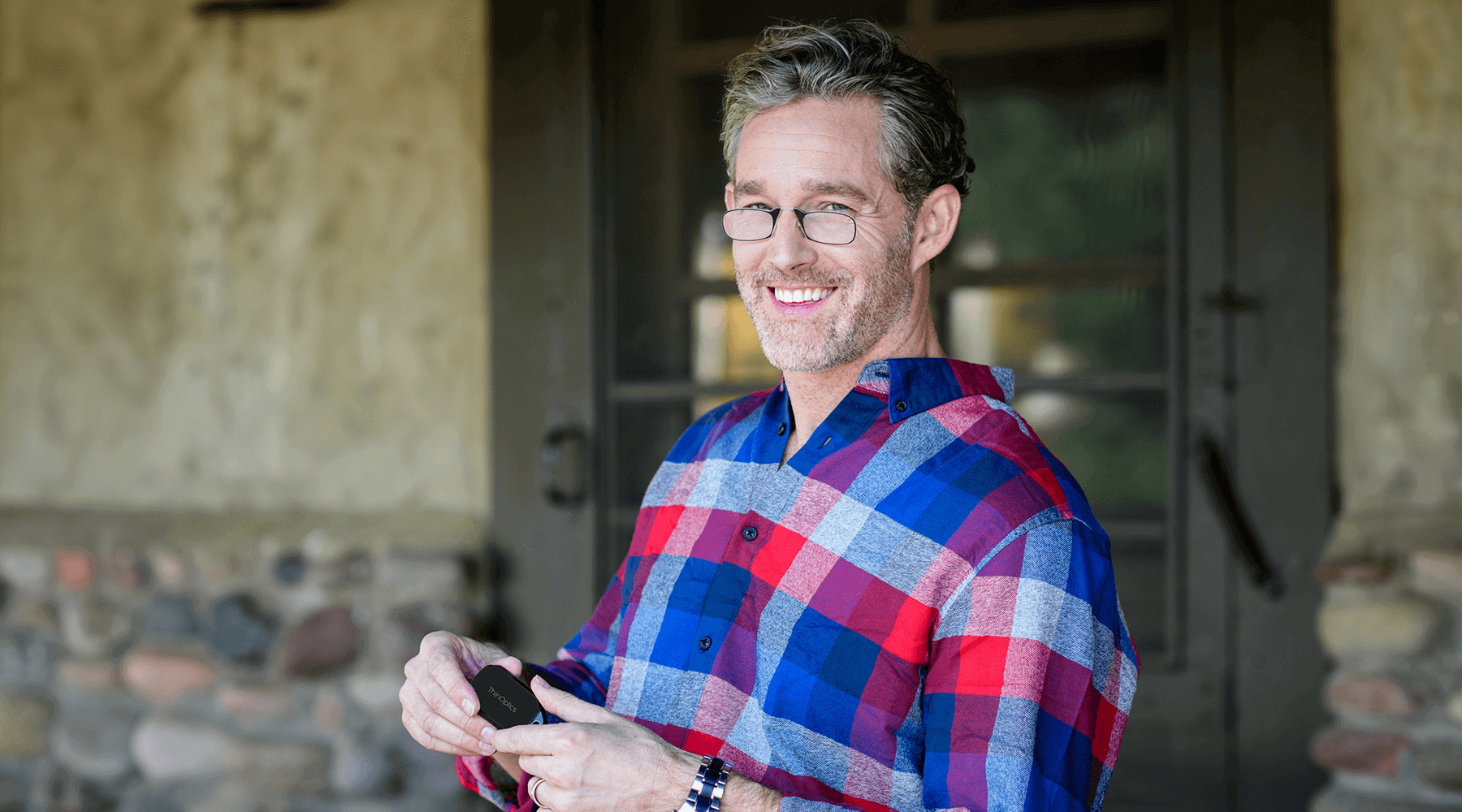 Man wearing Readers and holding a keychain case