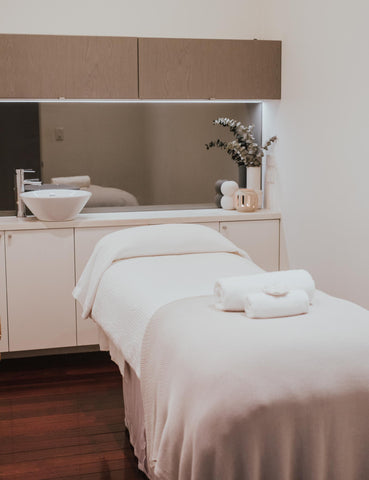 Image of the treatment bed in Mosman Spa, with rolled towels sitting on the bed sheets