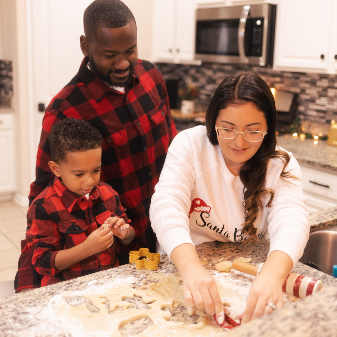 mother father and son having fun baking christmas gingerbread cookies together