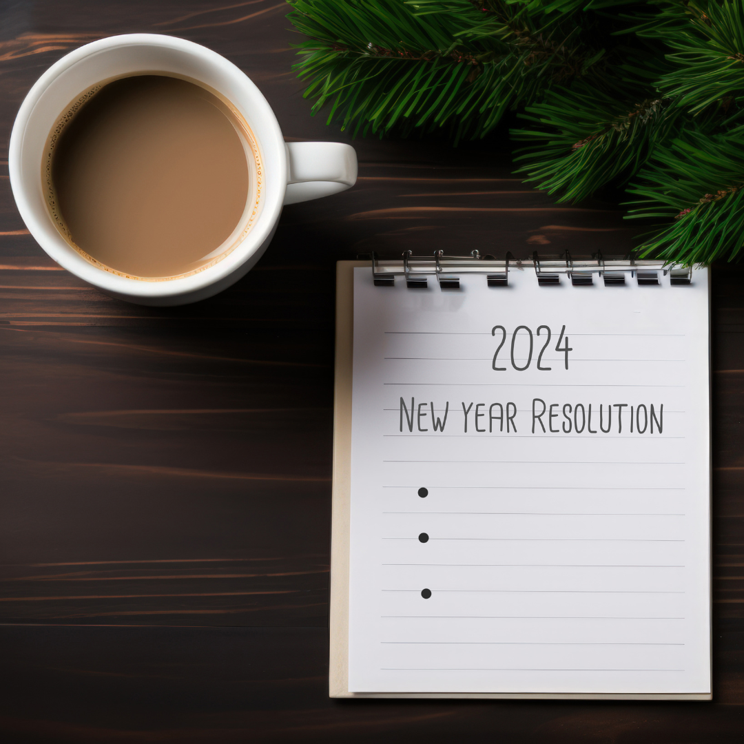 notepad with 2024 new year resolutions on table next to pine and coffee mug