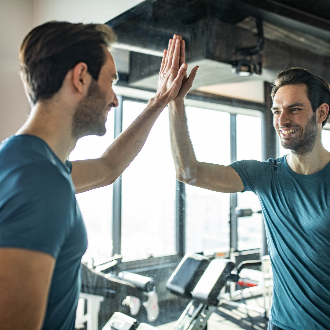 man high-fiving himself in a mirror proud of his accomplishments