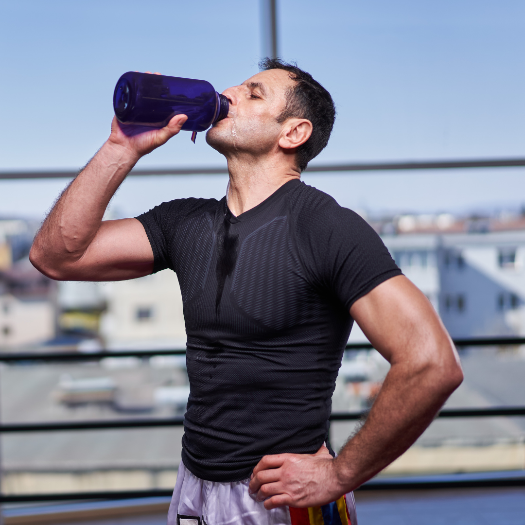man drinking water after a workout