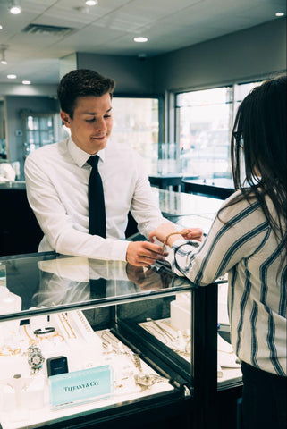 man assisting with jewelry purchase