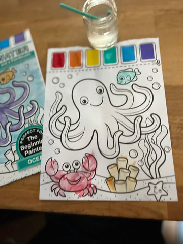Watercolor coloring sheet for babies and toddlers of an underwater scene with an octopus and crab with a clear jar of water and a paintbrush for dipping