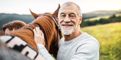 Smiling man with his horse. Rose-Hip Vital Equine