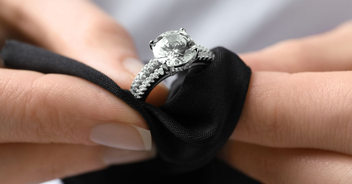 A jeweler polishes an engagement ring as part of an inspection and maintenance service. 