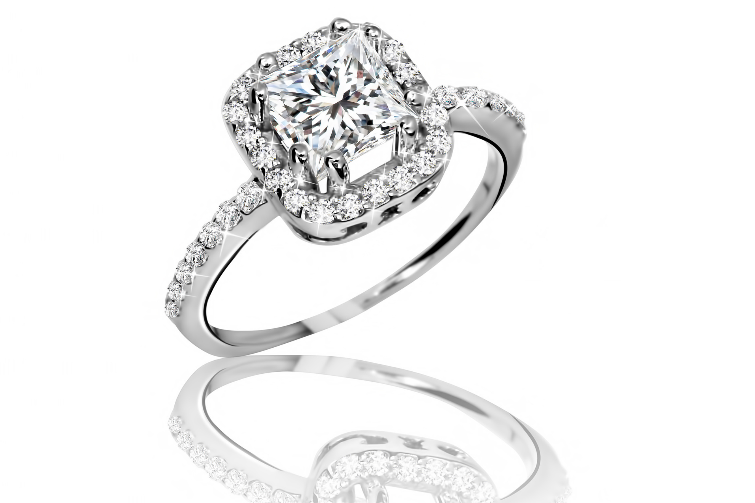A bridal ring engagement ring with a square cut center diamond, surrounded by a square of smaller diamonds. The white gold band is inlaid with smaller diamonds. 