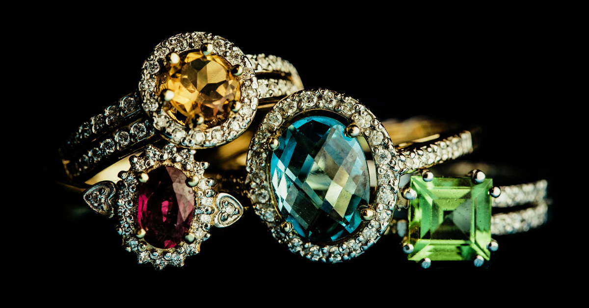 Four bridal rings with center gemstones that are not diamonds are pictured. 