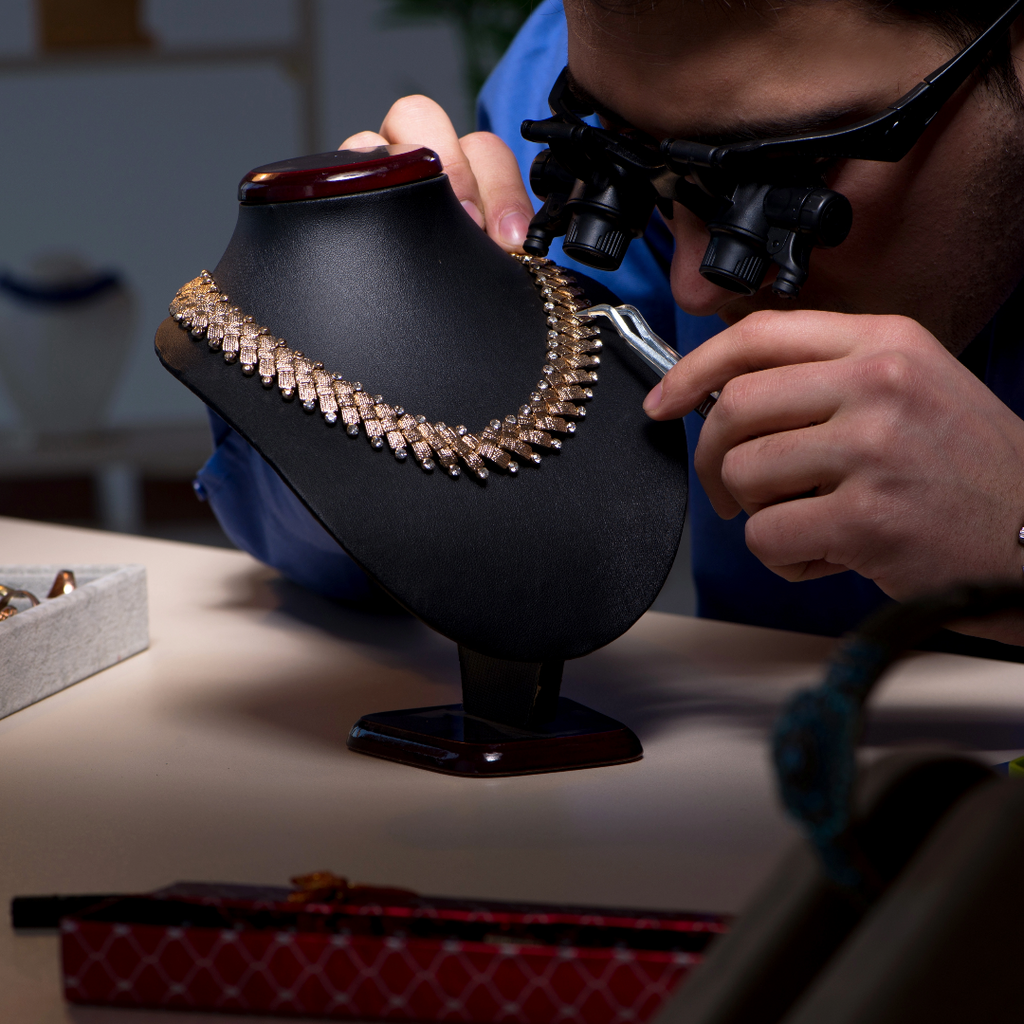 A jewelry appraiser conducts a jewelry appraisal on an antique necklace.