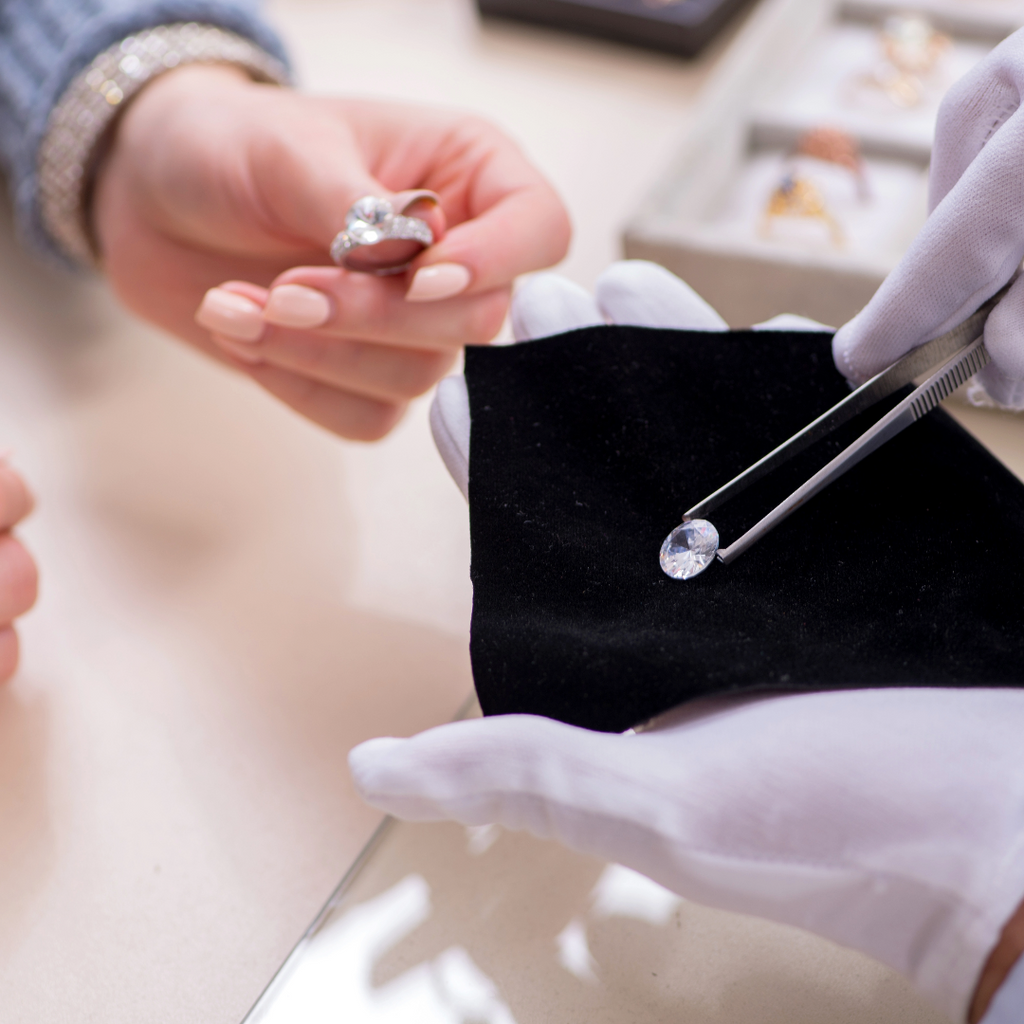 A jewelry appraiser examines a diamond ring against loose diamonds.