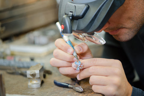 An Albquerque jeweler repairs the gemstones in a sterling silver ring. 
