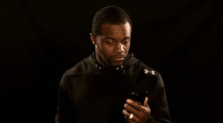 black man looking at phone with surprised expression gif