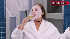 in a face mask and drinking wine gif