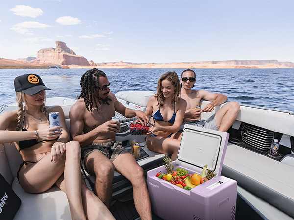 A Group of Friends Gathered on a Luxury Boat at Sea, Using a Colorful BougeRV Mini Fridge