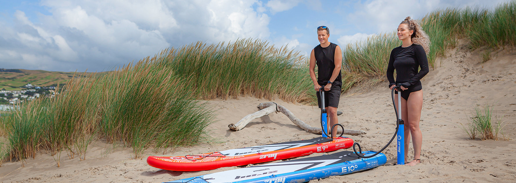 A couple pump up their inflatable SUP boards