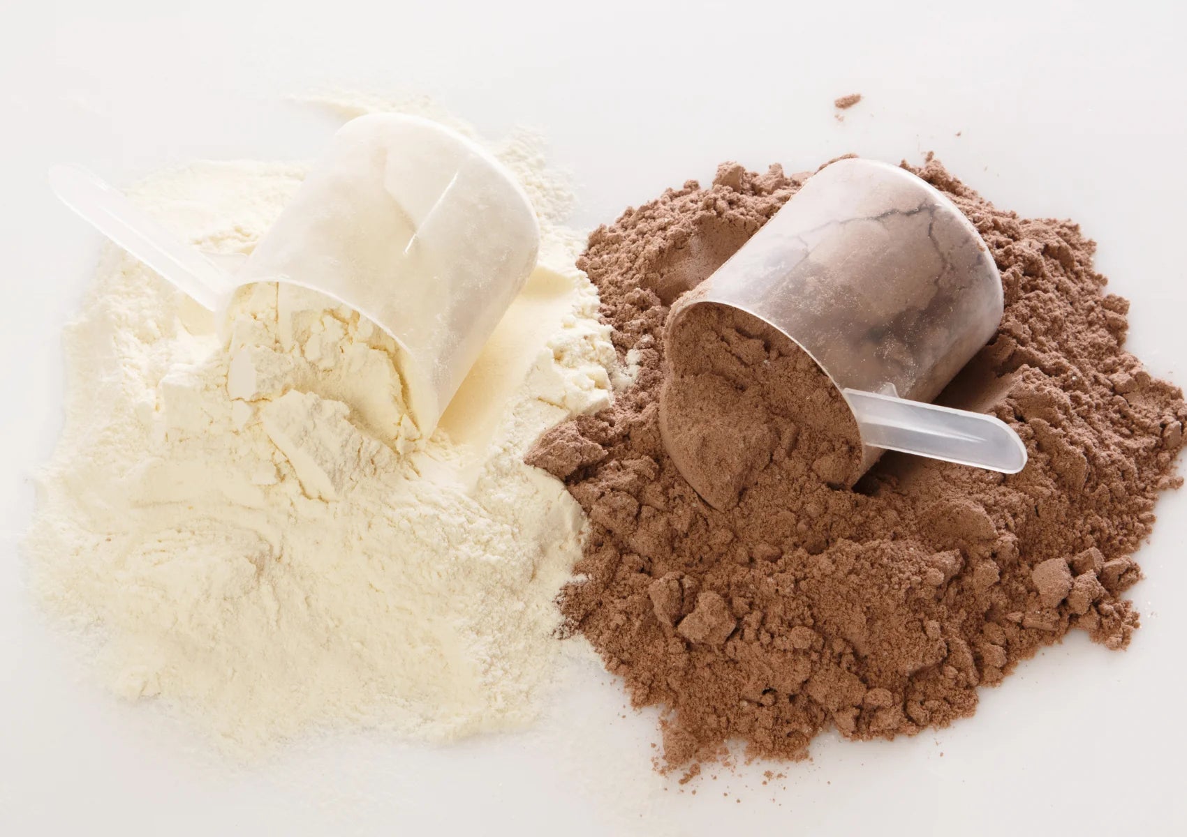 vanilla whey powder and chocolate protein powder in scoops