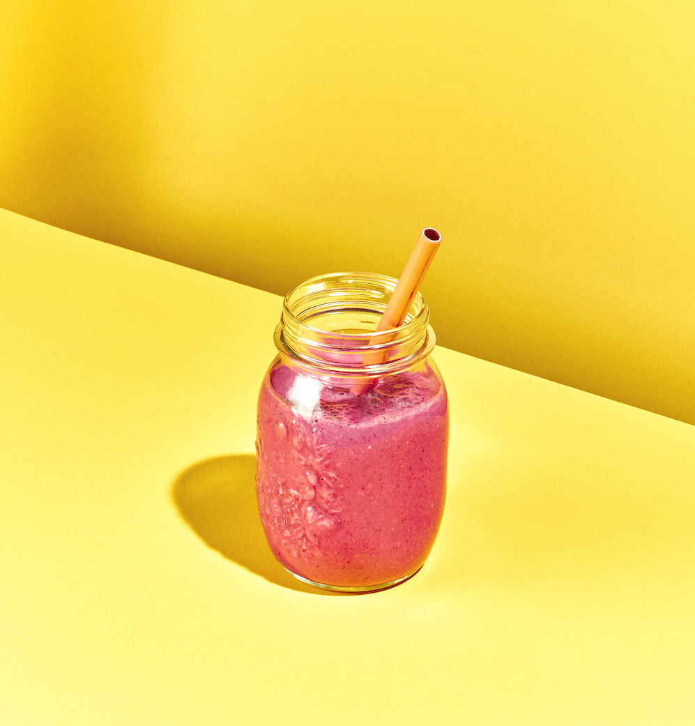 Lila Smoothie in Glas mit Strohhalm