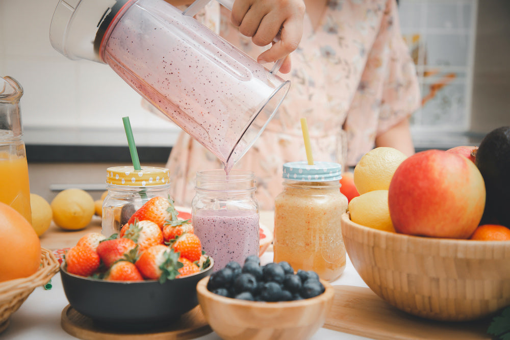 Mutter bereitet Smoothie zu