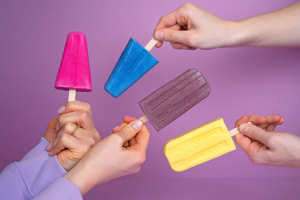 Bunte Popsicles auf lila Hintergrund