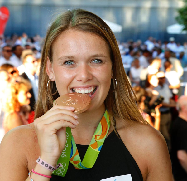 Anne Schröder bites on her medal