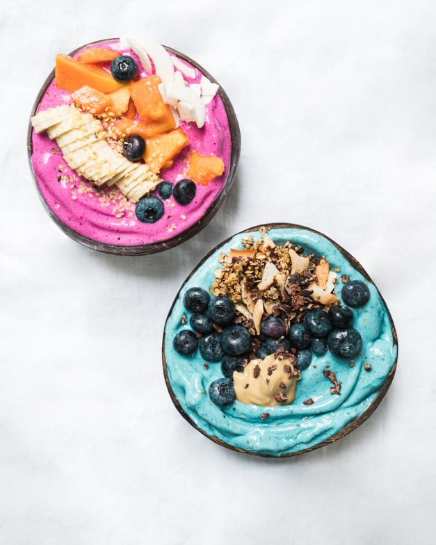 Two colorful smoothie bowls with toppings