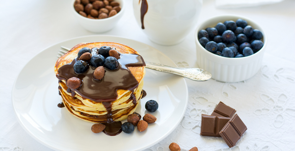 Pancakes mit Schokolade auf weißem Teller