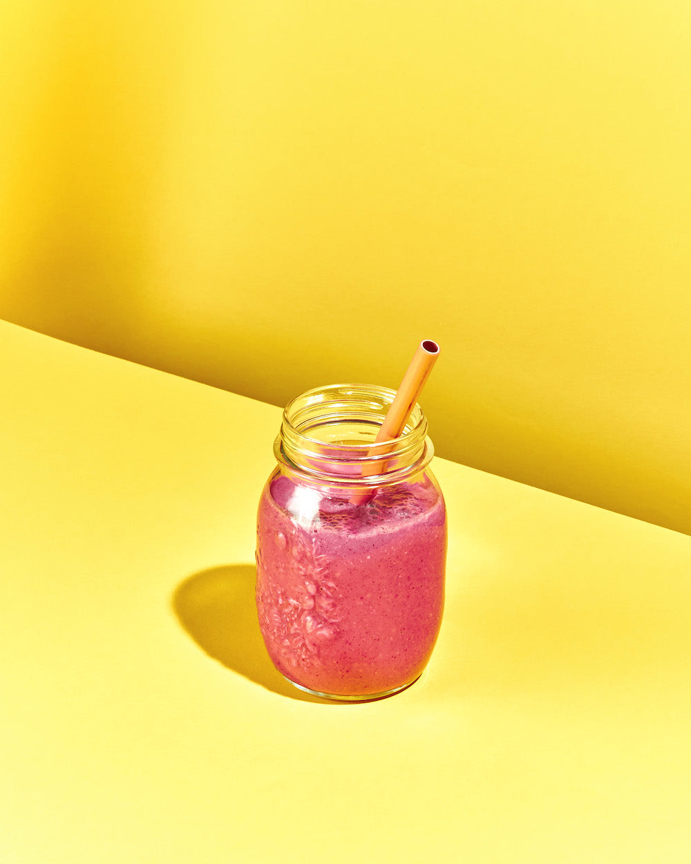 Rosa Smoothie mit Trinkhalm in Glas