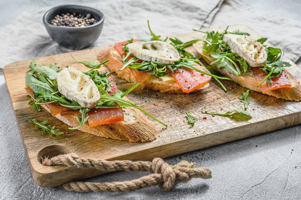 goat cheese bruschetta with black pear on a wooden patter