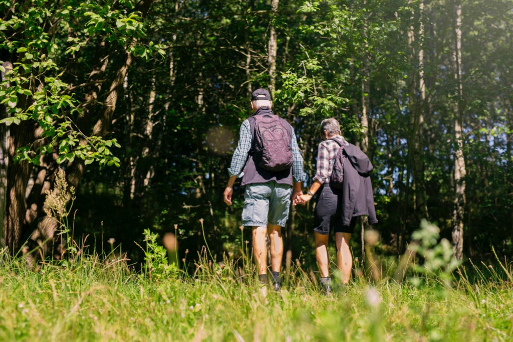 An older couple walking in the woods