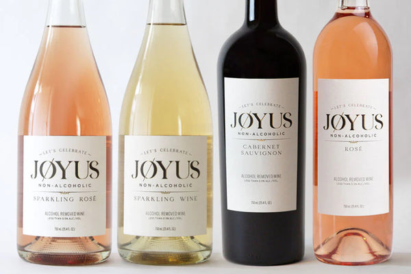 Four Bottles of Jøyus Sparkling Wine on a light grey background