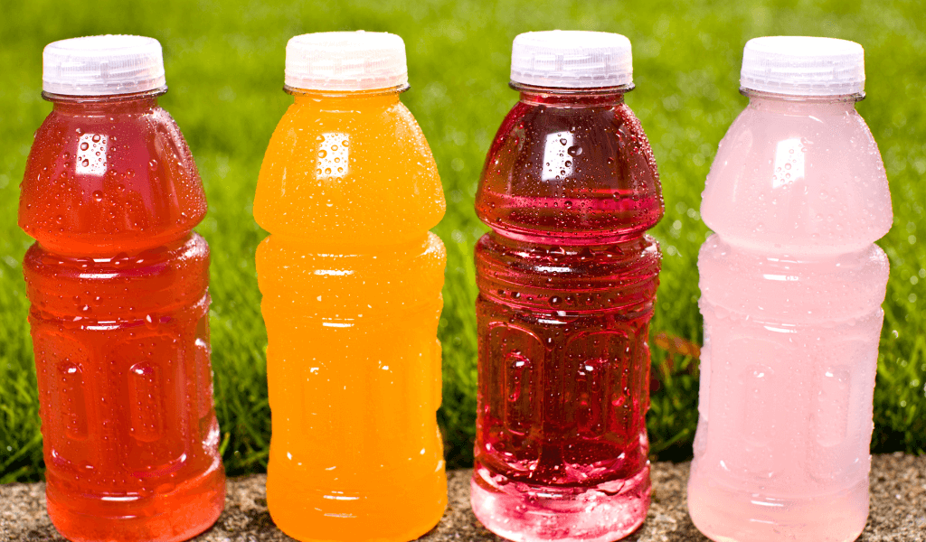 four bottles of water of different colors