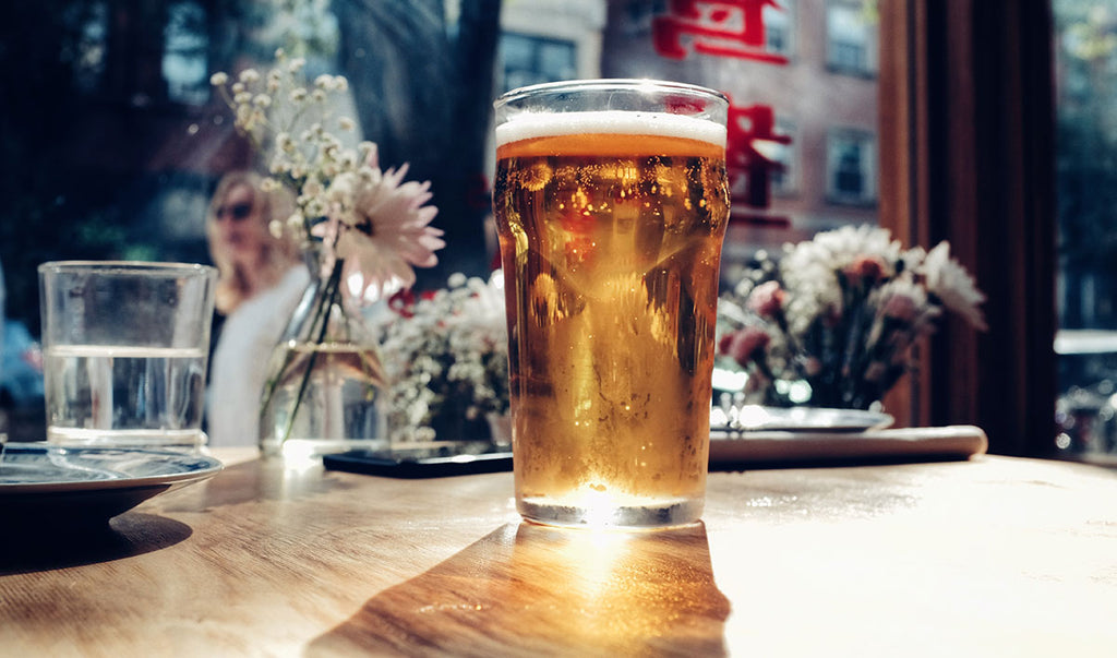 A pint of cider or beer on a table in a bar