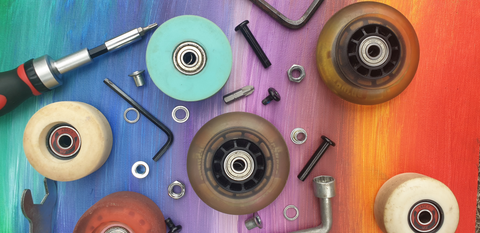 Skate maintenance tools, wheels and hardware on a rainbow gradient background