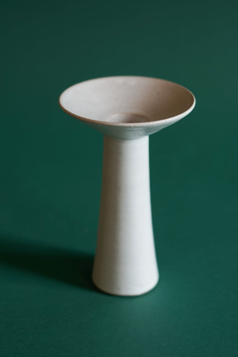 Cara Guthrie has created a collection of Midsummer Candlesticks for Bard. Pictured here in a white chalk glaze in the largest of three sizes.