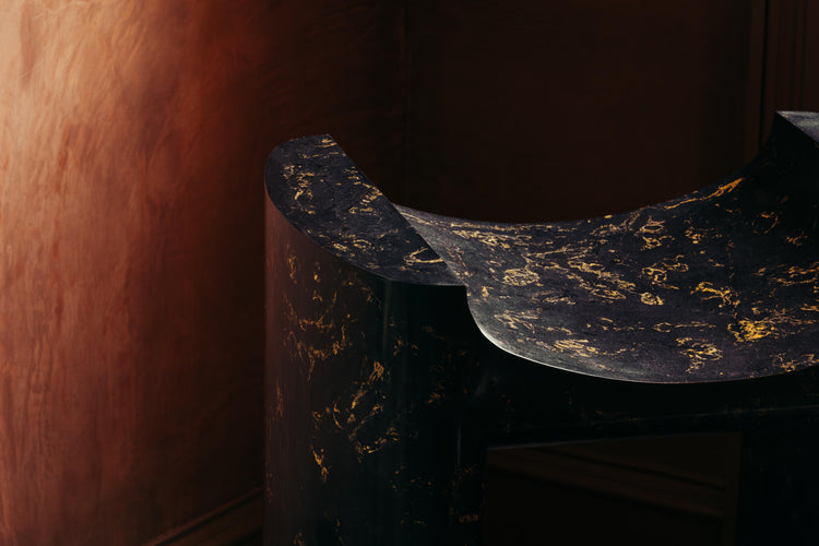  A close up shot of the Cat Throne, revealing the gold pigments mottled through the plaster cast structure. The seat has a bold shape, with pleasing curves.