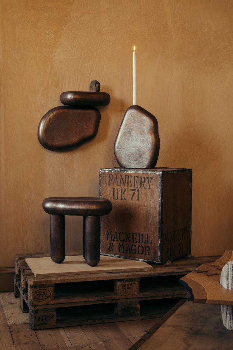  Ceramic Hermit Furniture by James Rigler. A three-legged table, candlestick, and shelf. In a deep bronze tone. Photographed at Bard Scotland, a gallery and shop in Leith, Edinburgh.